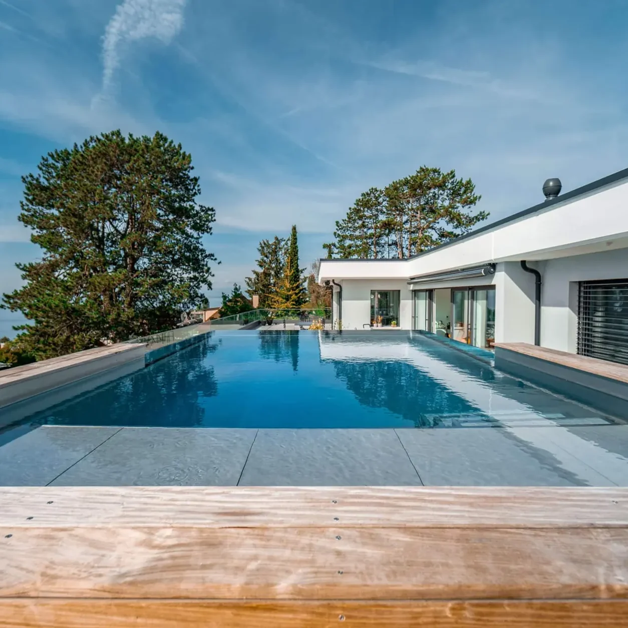Piscine miroir en inox, villa contemporaine et plage affleurante au soleil bas